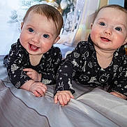 Ariana And Clara joined the competition — help win amazing prizes! baby, infant, child, smiling, lying_down, black_clothing, matching_outfits, blue_eyes, bed, blanket, indoor, portrait, cute, happy, holiday_theme, winter, decorations, face, hands, toddler