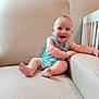 Grayson is registered to the contest to win money with this photo: baby, child, smiling, sitting, couch, armrest, romper, indoor, furniture, crib, happy, infant, portrait, face, skin, room, light, home, cute, young
