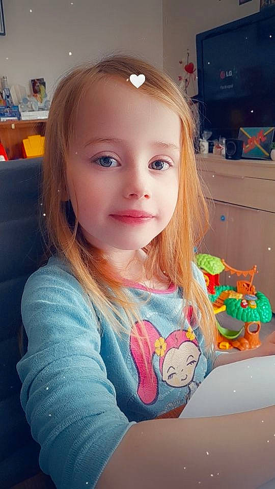 Manon a rejoint le concours — aidez-le/la à gagner de superbes lots ! baby_toddler_clothing, brown_hair, cheek, child, clothing, eyelash, fun, hair_coloring, happy, iris, long_hair, pattern, person, play, room, selfie, sitting, skin, sleeve, t_shirt