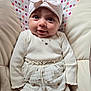 Maïa a rejoint le concours — aidez-le/la à gagner de superbes lots ! baby, child, smiling, hat, bow, white_clothing, cushion, polka_dot, pattern, sitting, portrait, cute, infant, happy, indoors, fabric, soft, person, closeup, face