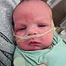 Ayden is registered to the contest to win money with this photo: newborn, baby, infant, face, portrait, close_up, hospital, medical_tube, nasal_cannula, medical_care, mint_green, clothing, serious_expression, eyes, head, skin, adult_hand, pacifier, indoor, photography