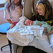 Ayden is registered to the contest to win money with this photo: child, newborn, baby, girl, teenager, family, sibling, portrait, indoors, window, chair, blanket, mint_green_clothing, headphones, smiling, sleeping, holding_baby, hospital_style_blanket, natural_light, home