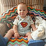 baby, superman, blue_shoes, knitted_blanket, striped_chair, smile, cute, indoors, child, sitting, colorful, cozy, blanket, clothing, person, portrait, happy, infant, cute_baby, soft_light