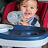 baby, bottle, cheeks, cheerful, child, clothing, cute, face, feeding, happy, high_chair, indoor, kitchen, portrait, seat, sippy_cup, smiling, table, toddler, young_child