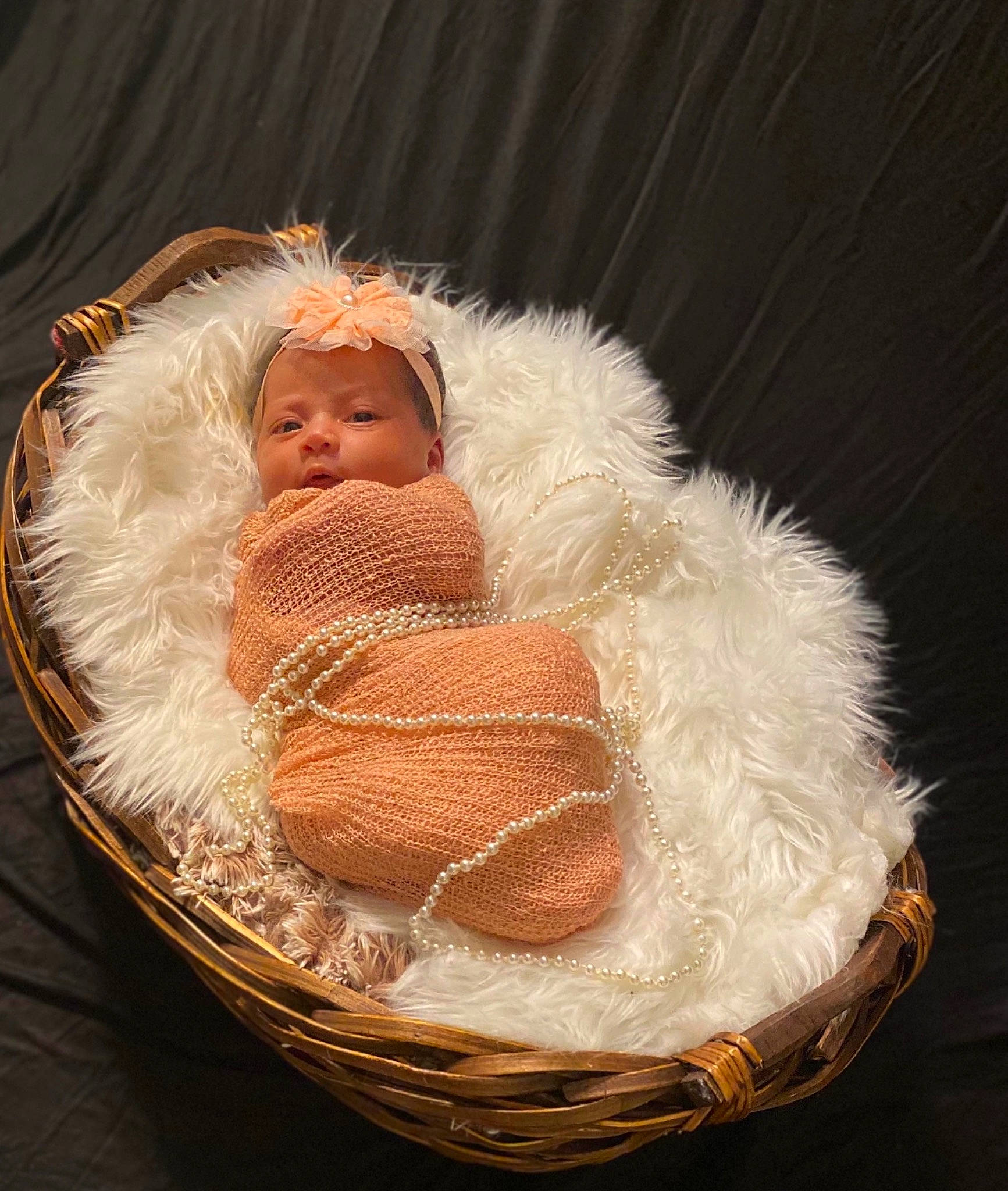 Lazayne is registered to the contest to win money with this photo: baby, baby_products, baby_sleeping, basket, beard, cap, comfort, costume_hat, event, fashion_accessory, fur, fur_clothing, hat, linens, person, sitting, toddler, wicker, wood, wool