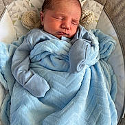 Theo is registered to the contest to win money with this photo: newborn, baby, sleeping, blanket, blue, bassinet, cozy, soft, infant, clothing, cute, peaceful, child, resting, face, head, indoors, warm, comfort, toddler