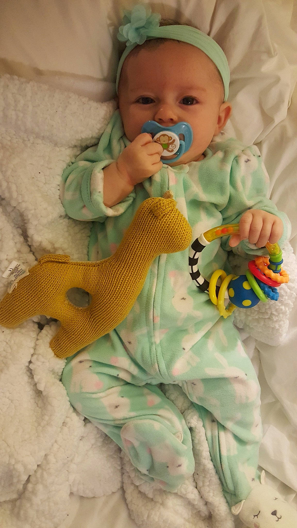 Briana is registered to the contest to win money with this photo: child, finger, green, head, headgear, infant, person, product, skin, textile, toddler, toy, vertebrate