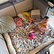 Elodie joined the competition — help win amazing prizes! baby, playpen, toys, blanket, pillow, teether, child, smile, happy, indoor, floor, plush_toy, colorful, cushion, person, infant, clothing, sitting, play, cute