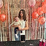 Ivy participe au concours pour gagner de l'argent avec cette photo : baby, child, woman, balloons, birthday, celebration, party, tinsel, decorations, table, can, drinks, black_cloth, face, person, indoor, event, smile, holding, curious