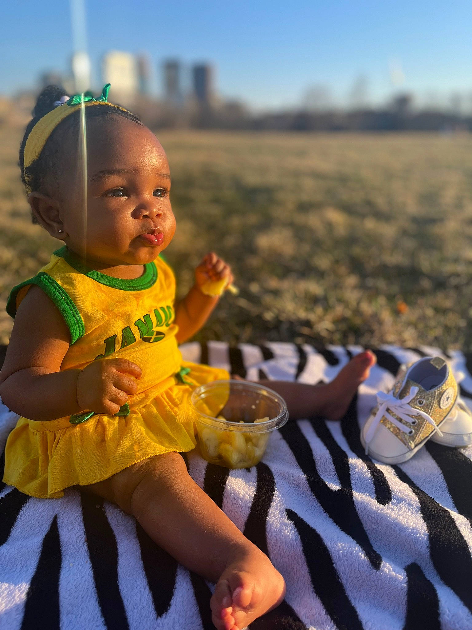 Journi is registered to the contest to win money with this photo: baby, baby_toddler_clothing, child, foot, fun, grass, happy, hat, headgear, human_leg, landscape, leisure, people_in_nature, person, recreation, sandal, sitting, sky, sunlight, toddler