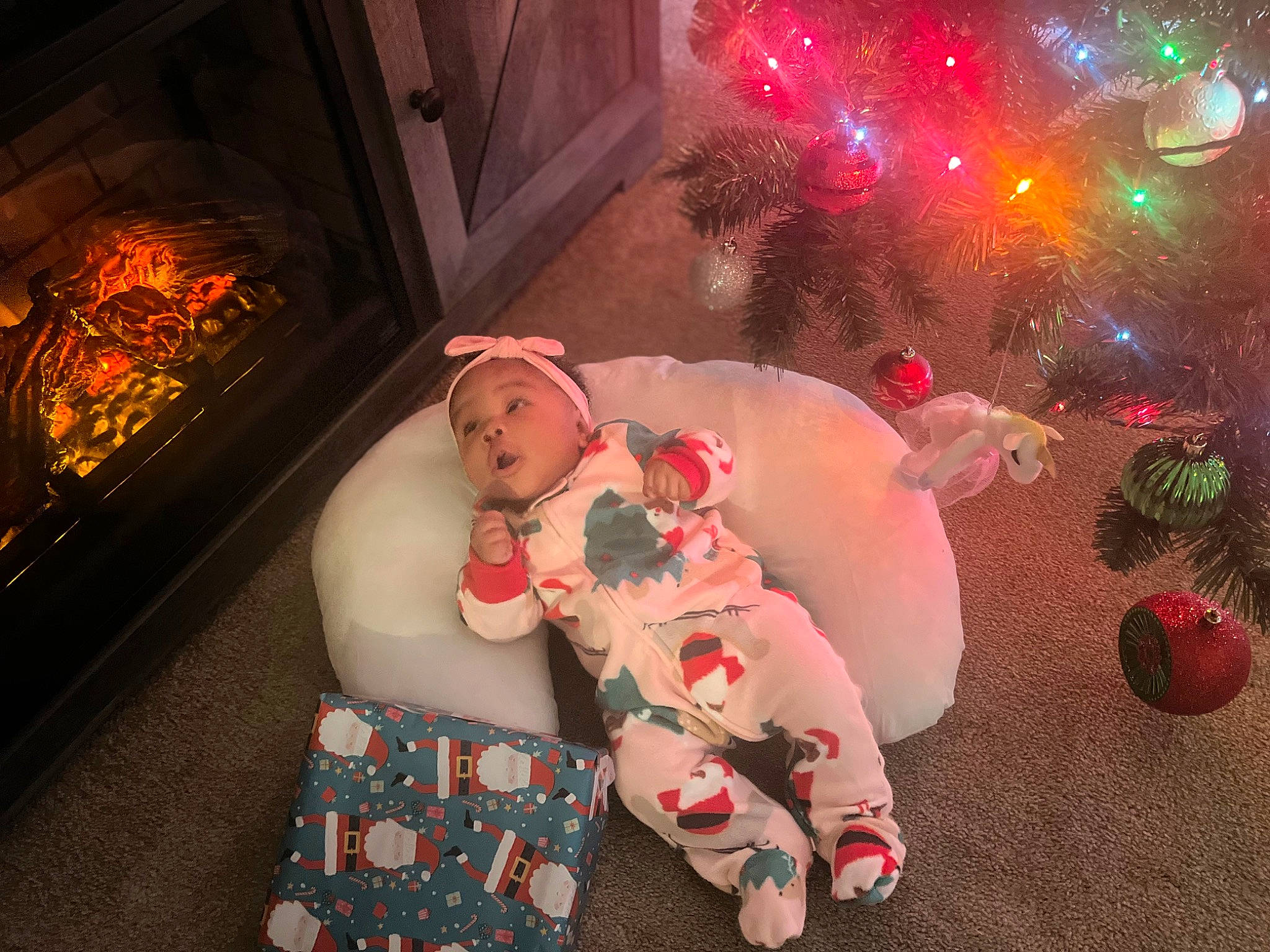 Journi is registered to the contest to win money with this photo: abdomen, baby, carmine, christmas, christmas_eve, christmas_tree, event, flesh, fun, happy, headwear, heat, holiday, lap, ornament, person, red, room, stove, teddy_bear