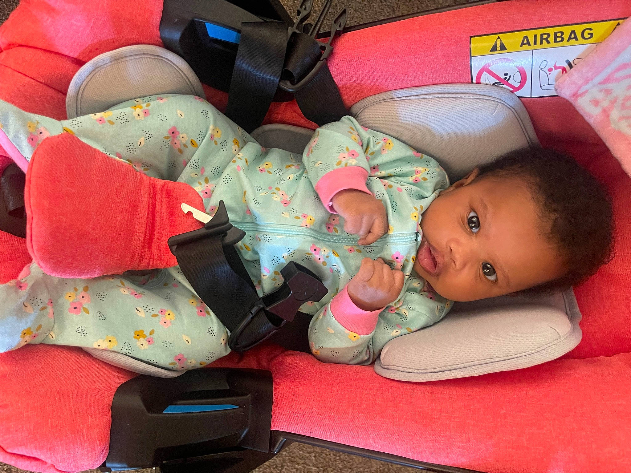 Nova is registered to the contest to win money with this photo: baby, baby_carriage, baby_products, baby_sleeping, baby_toddler_clothing, bag, car_seat, carmine, child, comfort, finger, human_body, lap, luggage_and_bags, person, pink, product, sitting, textile, thigh