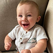 Dewayne is registered to the contest to win money with this photo: baby, smiling, happy, child, infant, couch, indoor, clothing, short_sleeve, sitting, face, cute, person, light_skin, portrait, young_child, explorer, buttoned_shirt, human, baby_girl