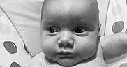 Kallie joined the competition — help win amazing prizes! baby, infant, face, skin, bath, seat, polka_dot, wide_eyes, expression, child, cute, water_droplets, young, portrait, indoors, head, arm, chubby, gaze, black_and_white