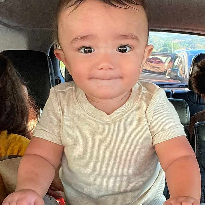 Gianni is registered to the contest to win money with this photo: baby, car_interior, car_seat, casual_clothing, child, curious, face, grip, hands, inside_car, looking_at_camera, person, portrait, seat, short_sleeves, smile, toddler, vehicle, window, young_child