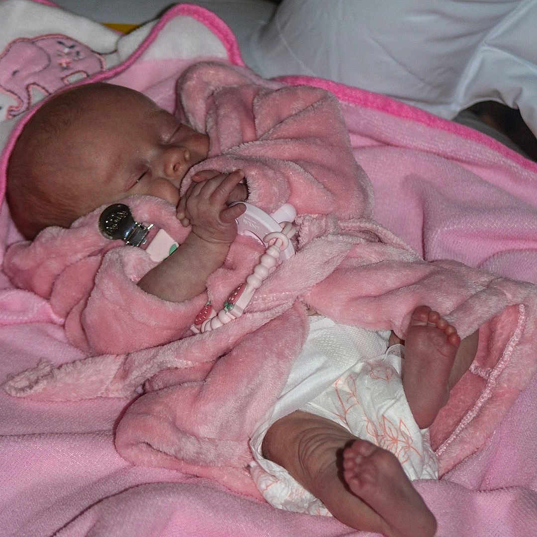 Evelyn Marie joined the competition — help win amazing prizes! baby, child, closeup, cozy, cute, diaper, face, foot, hand, human, indoors, infant, newborn, pacifier, pink_blanket, pink_robe, resting, sleep, sleeping, soft_texture