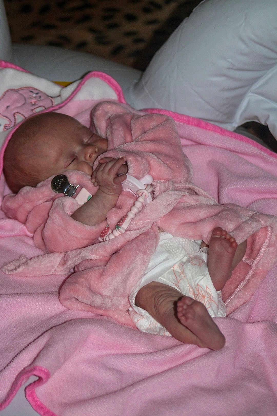 Evelyn Marie joined the competition — help win amazing prizes! baby, newborn, sleeping, pink_blanket, pink_robe, pacifier, diaper, foot, hand, infant, cozy, sleep, cute, indoors, soft_texture, closeup, face, human, resting, child