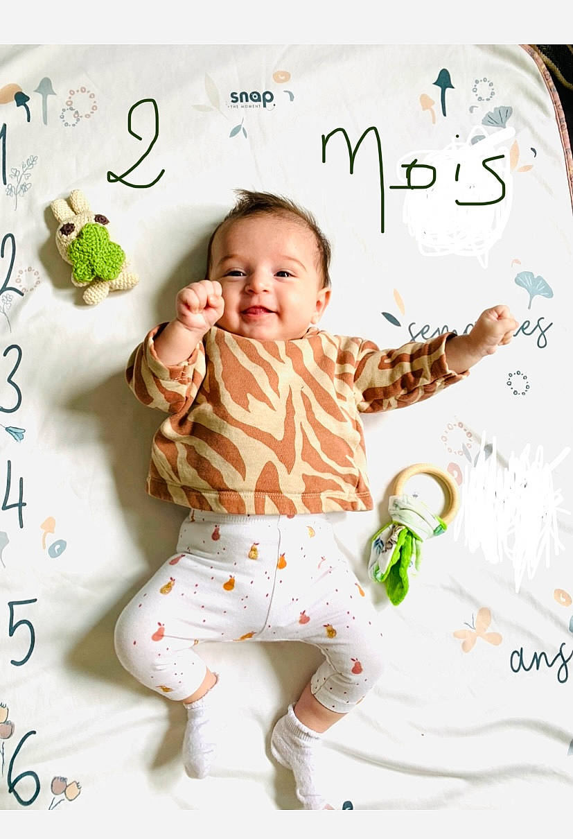 Louise a rejoint le concours — aidez-le/la à gagner de superbes lots ! baby, baby_toddler_clothing, bedding, child, font, happy, human, illustration, linens, pattern, peach, people, person, photo_caption, room, sleeve, smile, t_shirt, textile, toddler