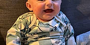 Caleb is registered to the contest to win money with this photo: baby, blanket, child, clothing, comfortable, couch, cozy, cute, face, happy, home, indoor, infant, pajamas, person, portrait, relaxed, sitting, smiling, young