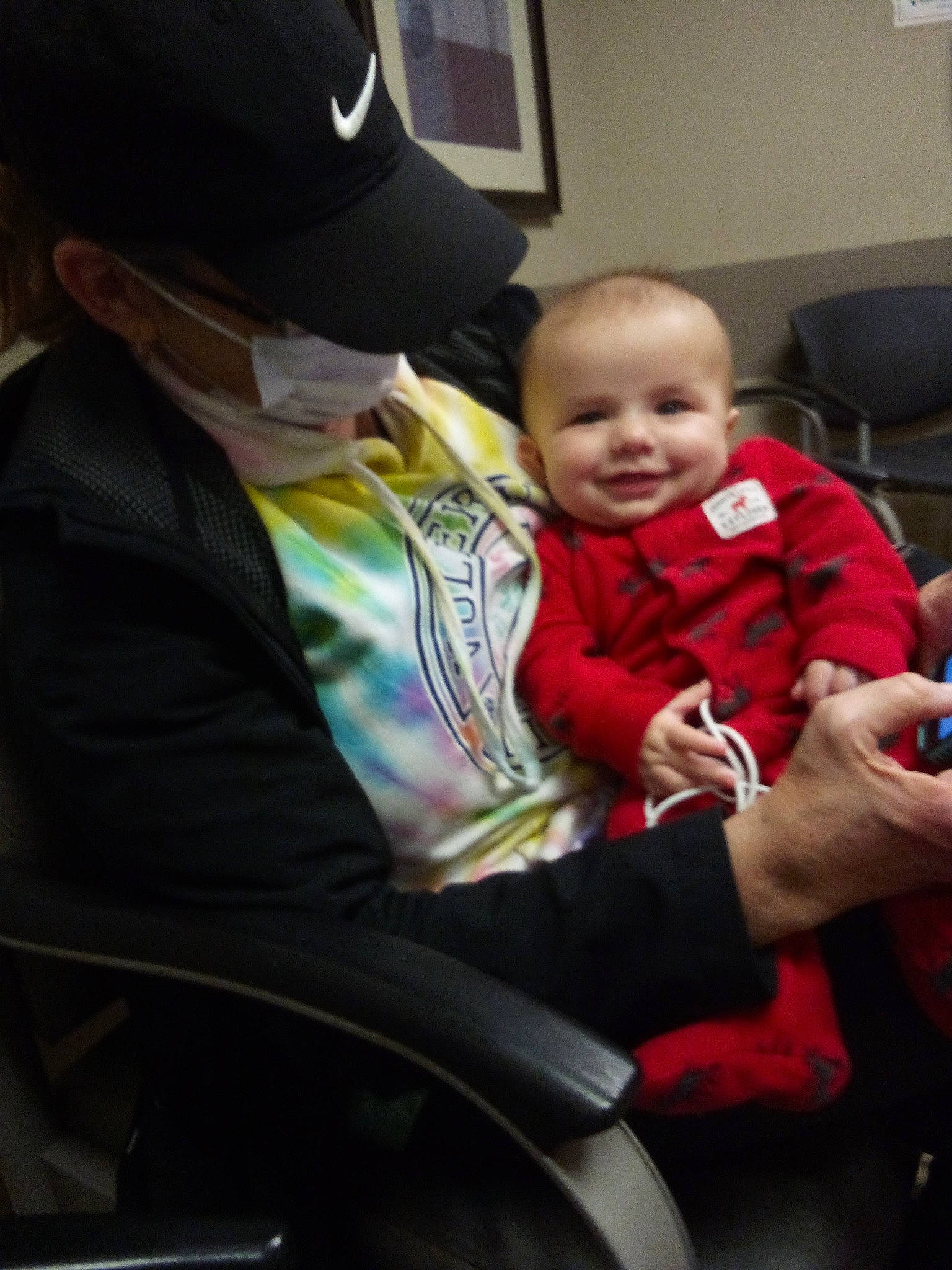 Mark is registered to the contest to win money with this photo: baby, baseball_cap, cap, car_seat, chair, child, comfort, event, facial_expression, fun, hairstyle, happy, interaction, joy, lap, person, picture_frame, sitting, smile, toddler