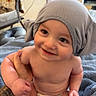 baby, child, infant, smiling, happy, portrait, gray_hat, diaper, indoor, home, blanket, adult_hand, tattoo, sitting, close_up, face, eyes, bare_skin, cozy, photography