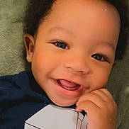 Marcus joined the competition — help win amazing prizes! toddler, child, smiling, face, eyes, hand, shirt, milk_carton_print, baby, cute, happy, lying_down, blanket, portrait, skin, hair, infant, playful, tongue, clothing