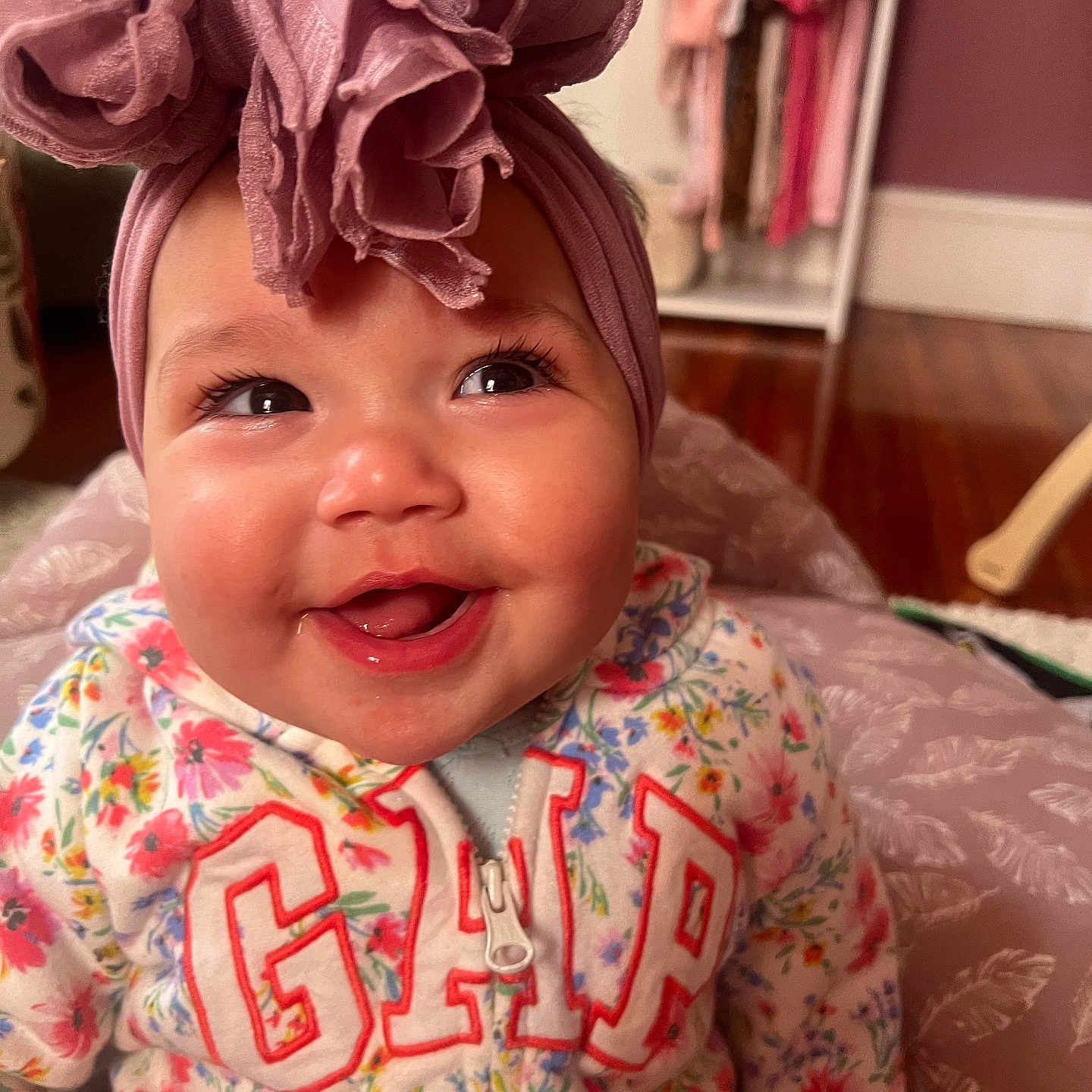 Azayliah is registered to the contest to win money with this photo: accessories, baby, bonnet, cap, clothing, couch, dress, face, furniture, happy, hardwood, hat, head, headband, indoors, person, photography, portrait, smile, wood