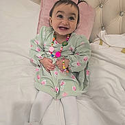 Mila participe au concours pour gagner de l'argent avec cette photo : baby, bed, child, cozy, cute, cute_expression, floral_pattern, furniture, green_dress, happy, indoor, jewelry, necklace, pigtails, pink_pillow, portrait, slippers, smiling, toddler, white_tights