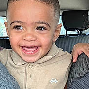 Isaac participe au concours pour gagner de l'argent avec cette photo : child, toddler, smiling, happy, face, eyes, polo_shirt, beige_clothing, car_interior, seat, seatbelt, person, portrait, cute, young_child, short_hair, skin, hand, window, daylight