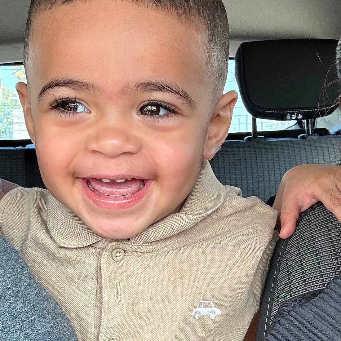 Isaac participe au concours pour gagner de l'argent avec cette photo : beige_clothing, car_interior, child, cute, daylight, eyes, face, hand, happy, person, polo_shirt, portrait, seat, seatbelt, short_hair, skin, smiling, toddler, window, young_child