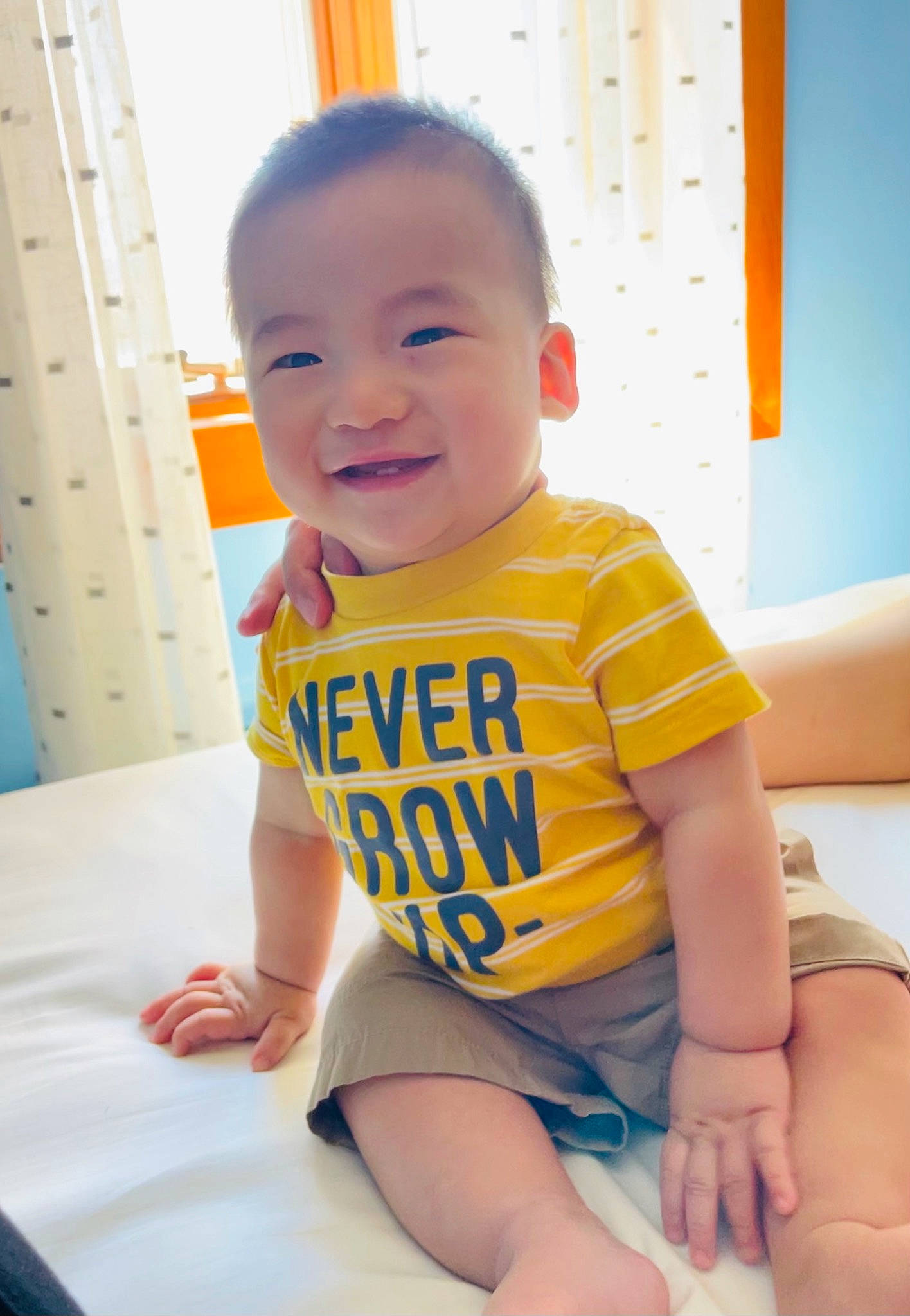 Philip is registered to the contest to win money with this photo: arm, baby, baby_toddler_clothing, blue, cheek, chin, finger, fun, happy, joint, joy, knee, leg, orange, person, shorts, skin, sleeve, smile, summer