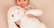 Rayan joined the competition — help win amazing prizes! baby, barefoot, bunny, child, comfort, cuddling, cute, face, happy, indoors, infant, plush, portrait, sitting, smiling, soft_toy, striped_shirt, stuffed_animal, toy, warm_colors