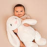 Rayan joined the competition — help win amazing prizes! baby, child, cuddling, stuffed_animal, bunny, plush, soft_toy, cute, smiling, striped_shirt, barefoot, indoors, portrait, warm_colors, happy, infant, toy, comfort, sitting, face