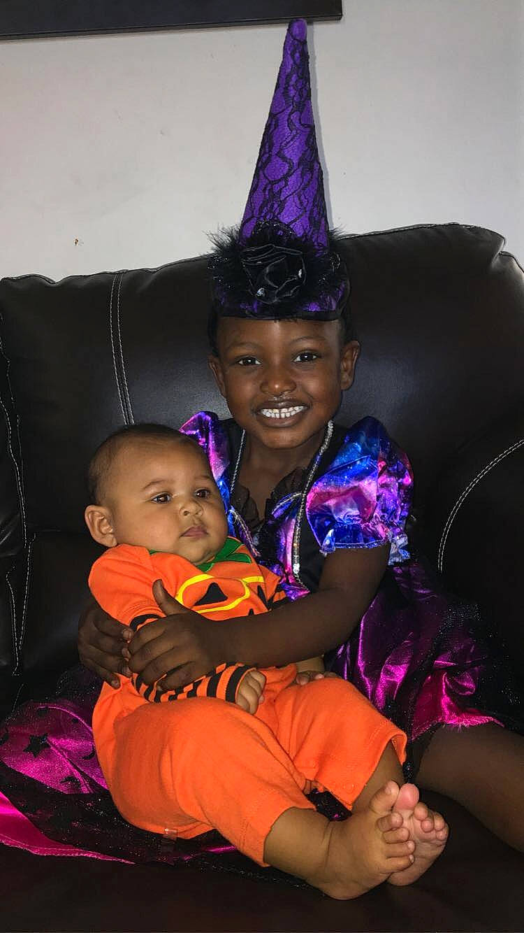 Ava is registered to the contest to win money with this photo: baby, baby_toddler_clothing, child, comfort, cone, costume_accessory, costume_hat, couch, hand, headgear, headwear, joy, lap, nail, party_hat, party_supply, person, purple, sock, toddler