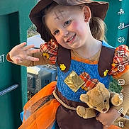 Addalynn is registered to the contest to win money with this photo: child, girl, smiling, costume, witch_hat, halloween, teddy_bear, peace_sign, outdoor, portrait, green_bins, waste_management, orange_dress, colorful_clothing, flower, face_paint, blonde_hair, happy, playful, photograph