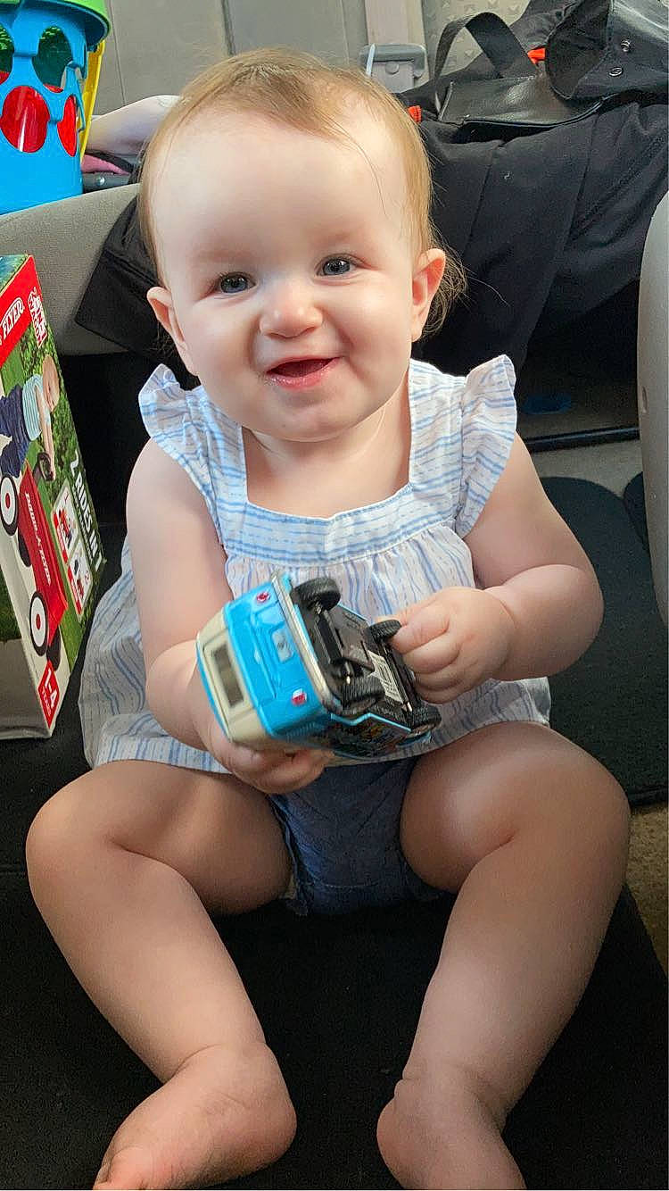 Aubrie is registered to the contest to win money with this photo: baby, baby_toddler_clothing, blond, cheek, child, comfort, facial_expression, finger, fun, hairstyle, happy, human_leg, joy, knee, lap, leg, person, sitting, skin, smile