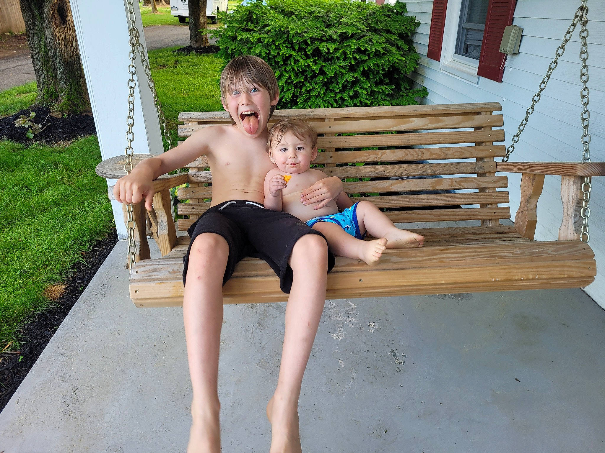 Jensen is registered to the contest to win money with this photo: barefoot, chest, face, foot, fun, grass, happy, houseplant, human_leg, knee, leisure, outdoor_furniture, person, plant, shorts, smile, thigh, toddler, tree, trunk