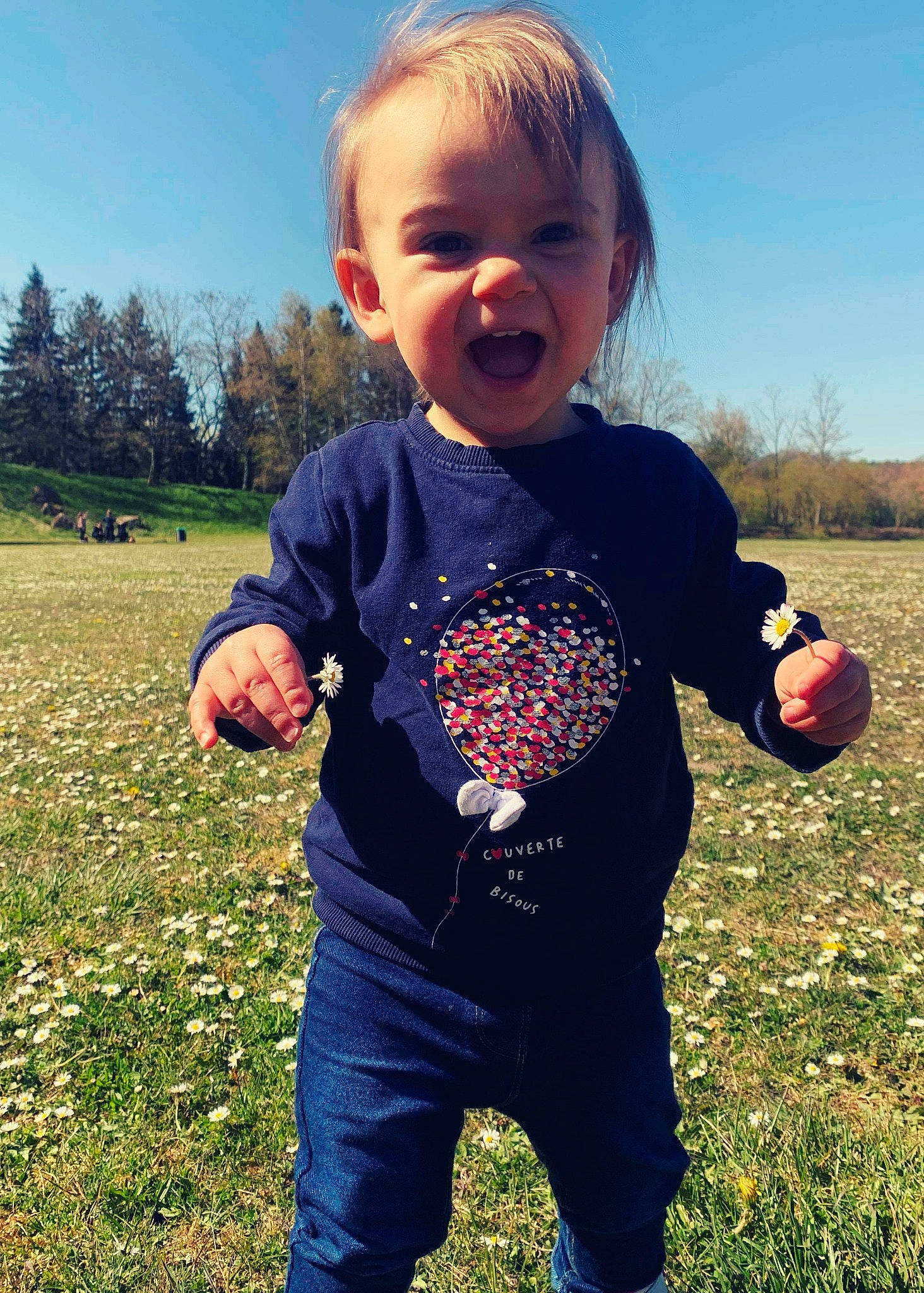 Louise participe au concours pour gagner de l'argent avec cette photo : baby_toddler_clothing, ball, facial_expression, finger, football, gesture, grass, hand, happy, head, leaf, people_in_nature, person, plant, sky, sleeve, smile, standing, sunlight, toddler