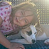 child, girl, dog, pet, companion, cuddle, portrait, smiling, sleepy, outdoor, sunlight, backlit, warm_light, closeup, animal, canine, face, hair, strawberry_pattern, relaxed