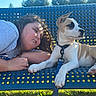 Steely Dan joined the competition — help win amazing prizes! child, dog, person, pet, cuddle, sleeping, outdoor, park, bench, blue_bench, sunlight, grass, leash, collar, white_dog, tan_dog, long_ears, portrait, companion, candid