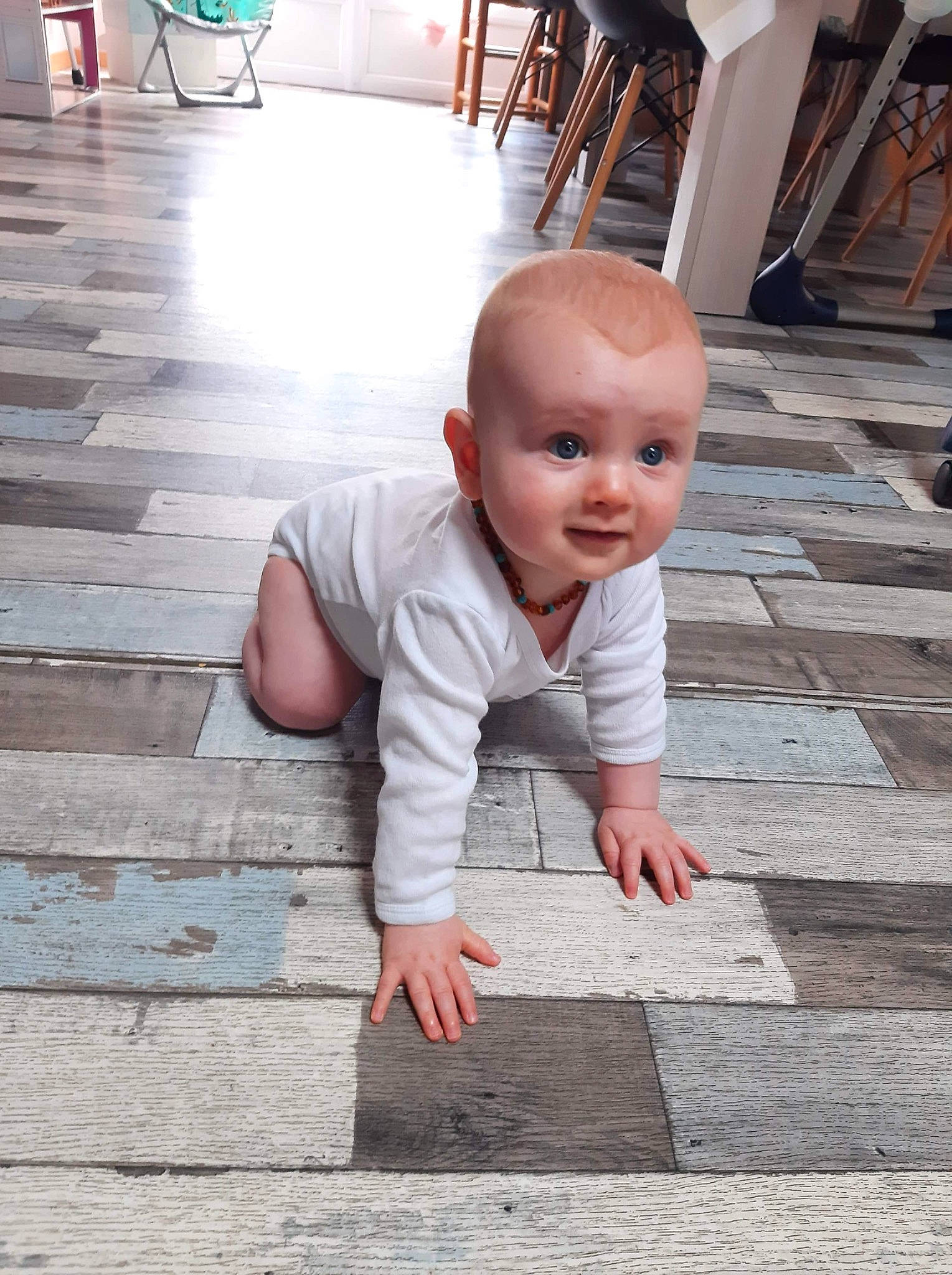 Aubin a rejoint le concours — aidez-le/la à gagner de superbes lots ! asphalt, baby, baby_toddler_clothing, chin, dress, facial_expression, floor, flooring, hairstyle, hand, happy, hardwood, person, road_surface, sidewalk, skin, smile, standing, toddler, white