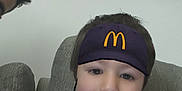 Ethann a rejoint le concours — aidez-le/la à gagner de superbes lots ! child, pacifier, hat, mcdonalds_logo, headset_filter, couch, sofa, portrait, indoors, wall, elephant_painting, bead_chain, pacifier_clip, shirtless, person, partial_person, selfie, living_room, neutral_expression, gray_fabric