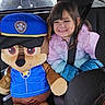 Athena Allred is registered to the contest to win money with this photo: child, smiling, plush_toy, car_interior, seat_belt, jacket, toy, police_hat, vehicle, window, seat, young_child, happy, indoor, passenger, car_seat, stuffed_animal, cute, childhood, transportation
