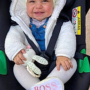 Lehna a rejoint le concours — aidez-le/la à gagner de superbes lots ! baby, car_seat, smiling, white_jacket, denim_overalls, toy, stuffed_animal, head_wrap, child, footwear, shoe, seatbelt, cute, infant, happy, portrait, indoors, closeup, pink_text, bunny_toy