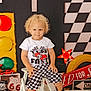 Caleb joined the competition — help win amazing prizes! black_shoes, checkered_flag, checkered_shorts, child, curly_hair, decor, indoor, ladder, photography, playful, posing, racing_theme, red_star_light, route_66_sign, smiling, toddler, toy_car, traffic_light, white_tshirt, yellow_tire