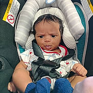 Dedrick joined the competition — help win amazing prizes! baby, infant, car_seat, straps, blue_socks, curly_hair, white_outfit, padded_cushion, safety_warning, child, seat_belt, cute, indoor, expression, face, person, newborn, small_hands, footwear, closeup