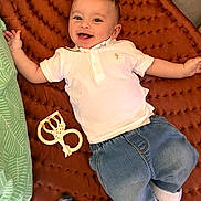 Soan a rejoint le concours — aidez-le/la à gagner de superbes lots ! baby, smiling, child, polo_shirt, jeans, teething_toy, blanket, lying_down, happy, cute, infant, casual_clothing, indoor, playtime, portrait, young_child, head, face, hand, footwear