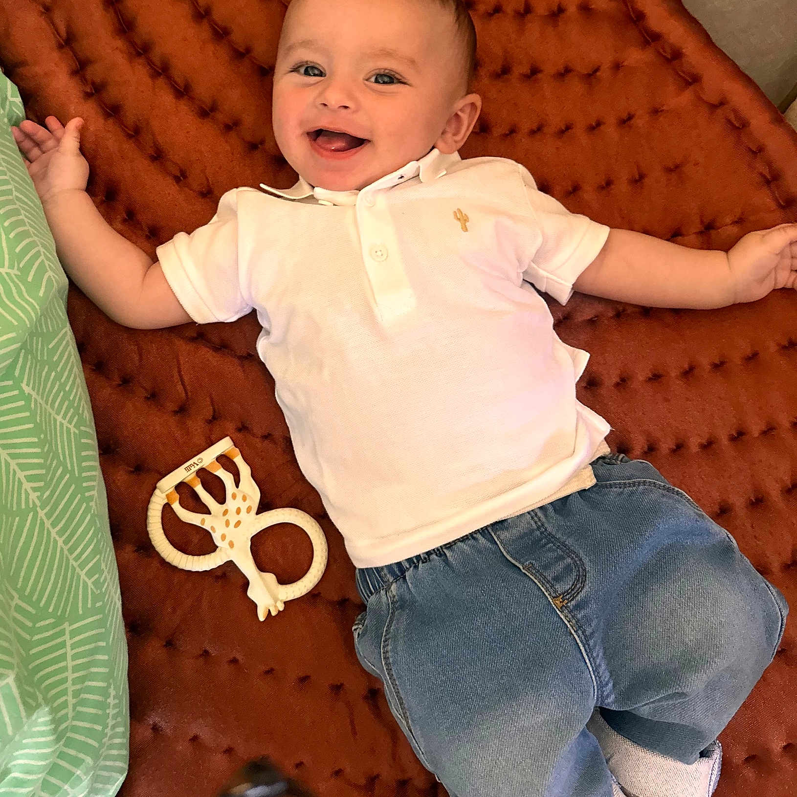 Soan a rejoint le concours — aidez-le/la à gagner de superbes lots ! baby, smiling, child, polo_shirt, jeans, teething_toy, blanket, lying_down, happy, cute, infant, casual_clothing, indoor, playtime, portrait, young_child, head, face, hand, footwear