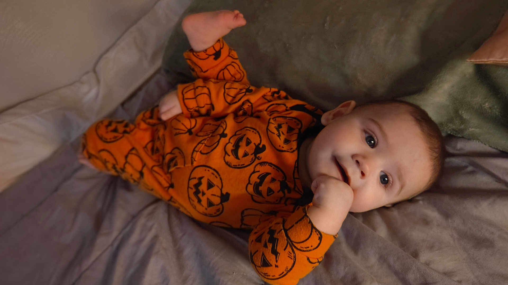 Justin joined the competition — help win amazing prizes! baby, infant, orange_clothing, pumpkin_pattern, bed, blanket, cozy, cute, face, hand, foot, lying_down, child, indoors, portrait, smiling, looking_at_camera, sleepwear, soft_fabric, playful
