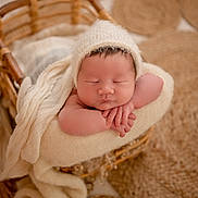 Eden participe au concours pour gagner de l'argent avec cette photo : newborn, baby, sleeping, basket, blanket, knit_hat, cozy, infant, resting, soft_texture, warm_colors, portrait, cute, hands, peaceful, indoors, fabric, woven, headwear, closeup